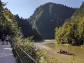 Ścieżka pieszo-rowerowa nad Dunajcem, w tle góry i tratwa.