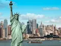 Statua Wolności wita podczas podróży do USA. W tle panorama Nowego Jorku z drapaczami chmur i statkami na rzece.