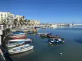 Widok na port w Bari z łodziami i budynkami w tle.