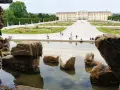 Wiedeń ogrody Sisi: malowniczy widok na pałac Schönbrunn i jego kwieciste tarasy, z kamienną fontanną w pierwszym planie.