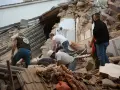 Ratownicy przeszukują gruzy po trzęsieniu ziemi we Włoszech. Zniszczone budynki i chaos po katastrofie.