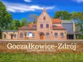 Ceglana stacja kolejowa Goczałkowice-Zdrój z czerwonym dachem i zielonymi drzewami w tle.