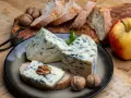Kawałki sera gorgonzola z niebieską pleśnią, podane z chlebem, orzechami i jabłkiem. Idealne na przekąskę, która odpowie na pytanie: co to gorgonzola.