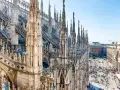 Majestatyczne iglice katedry Duomo w Mediolanie w listopadzie, z widokiem na tętniący życiem plac poniżej.