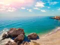 Piękne wybrzeże Costa del Sol z białymi domkami na klifie, turkusowym morzem i skalistą plażą. Idealne miejsce na wakacje!