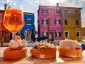 Co zjeść w Wenecji? Aperol i bruschetty na tle kolorowych domów Burano. Idealne połączenie smaków i widoków.