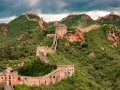 Wielki Mur Chiński, jeden z najbardziej rozpoznawalnych obiektów UNESCO na świecie, pnie się po zielonych wzgórzach.