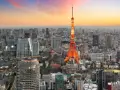 Widok na Tokio, jedno z 10 największych miast na świecie, z wieżą Tokyo Tower w pomarańczowych barwach o zachodzie słońca.