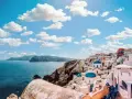 Santorini, Grecja. W jakim języku mówi się w Grecji? Po grecku! Białe domy, niebieskie kopuły i morze.