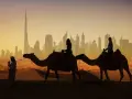Karawana wielbłądów na tle Dubaju, miasta na kontynencie azjatyckim.