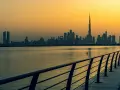 Zachód słońca nad Dubajem. Zjednoczone Emiraty Arabskie ciekawostki: najwyższy budynek świata, Burj Khalifa, góruje nad panoramą miasta.