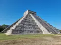 Piramide Kukulkana w Chichen Itza, jeden z Nowych Siedmiu Cudów Świata, majestatycznie wznosi się na tle błękitnego nieba.