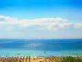 Słoneczna plaża w Bułgarii, idealna na wrzesień. Temperatura wody i powietrza zachęca do kąpieli i relaksu pod parasolami.