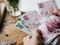 Ręka trzyma banknoty 10 i 20 lir tureckich. To pokazuje, czym płacić w Turcji.
