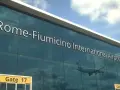 Lotnisko Rzym Fiumicino. Jak dojechać do centrum? Widok na nowoczesny budynek lotniska z napisem "Rome-Fiumicino International Airport" i odbijającym się samolotem.