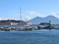 Widok na zatokę w Neapolu z łodziami i Wezuwiuszem w tle.