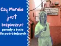 Kobieta w okularach przeciwsłonecznych stoi na tle uliczki w Maroku z napisem "Place Djemaa El Fna".