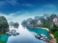 Zatoka Ha Long we Wietnamie z łodziami i skalistymi wyspami.