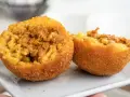Arancini co to? Chrupiące kulki ryżowe z mięsnym farszem i groszkiem, przekrojone na pół, prezentują swoje bogate wnętrze.