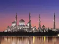 Wspaniały meczet oświetlony nocą, odbijający się w wodzie. Idealny widok, kiedy jest Ramadan.