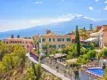 Widok na Sycylię z Etna w tle. Urokliwe miasteczko z hotelami, basenem i bujną zielenią. Idealne miejsce, gdzie na Sycylię.