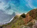Widok z góry na klif Madery, pola uprawne i ocean.