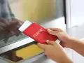 Ręce trzymają czerwony paszport z biletem lotniczym. Pamiętaj, czego nie wolno wywozić z Sycylii, by uniknąć problemów.
