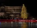 Świąteczna choinka rozświetla nocne niebo, a światła samochodów tworzą smugi na mokrej ulicy. To magiczne Boże Narodzenie we Włoszech.