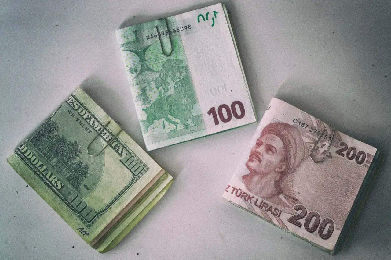 Stos banknotów 200 lir tureckich obok euro i dolarów. Waluta w Turcji to lira.