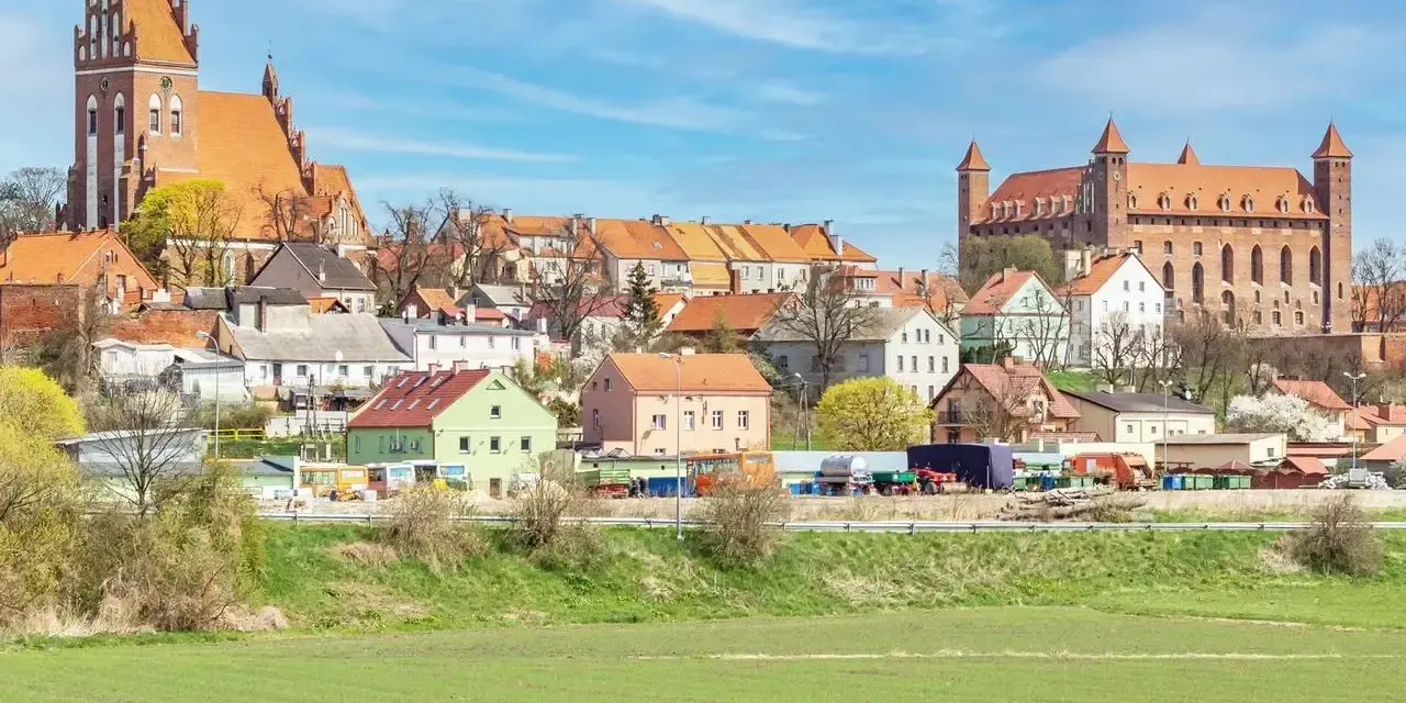 Zamek w Gniewie - ciekawostki. Imponująca twierdza i urokliwe miasteczko na tle błękitnego nieba.