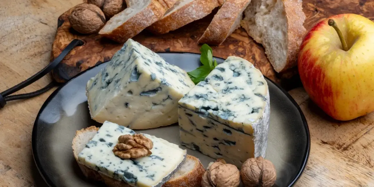 Kawałki sera gorgonzola z niebieską pleśnią, podane z chlebem, orzechami i jabłkiem. Idealne na przekąskę, która odpowie na pytanie: co to gorgonzola.