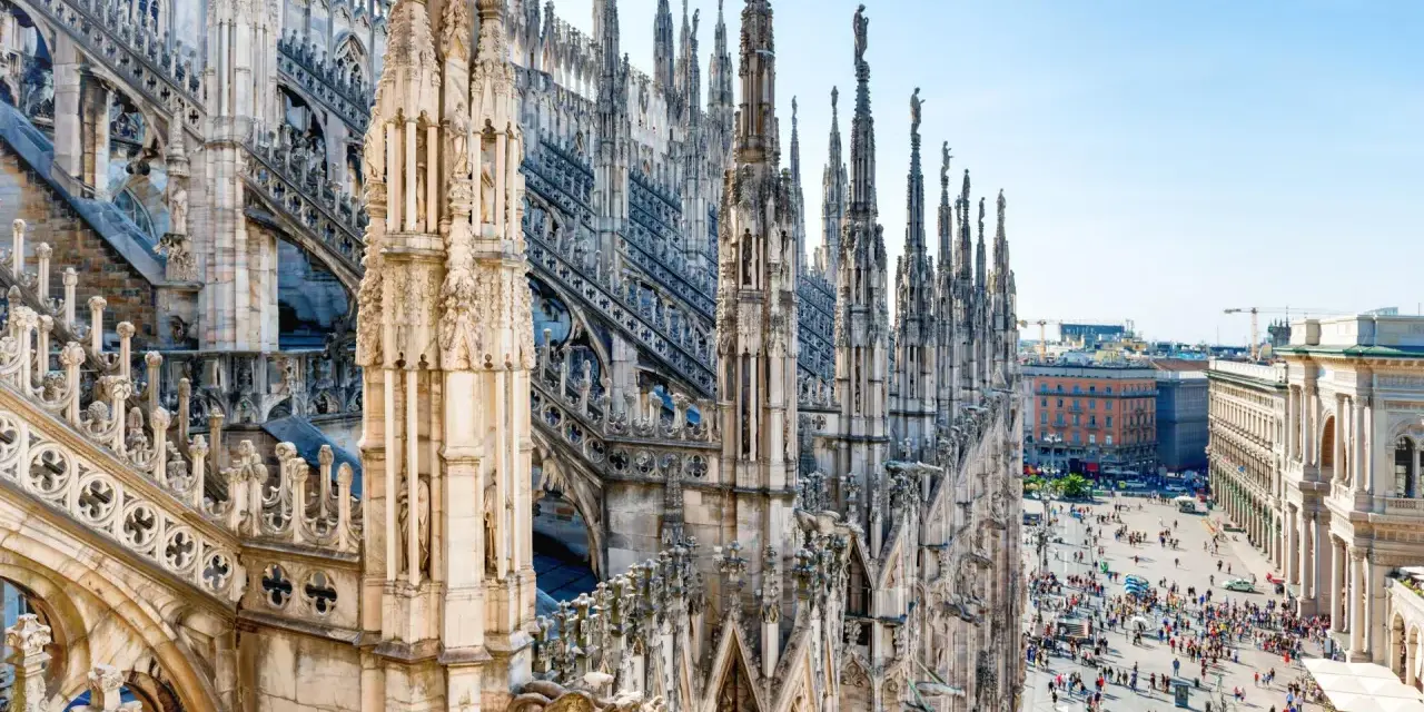 Majestatyczne iglice katedry Duomo w Mediolanie w listopadzie, z widokiem na tętniący życiem plac poniżej.