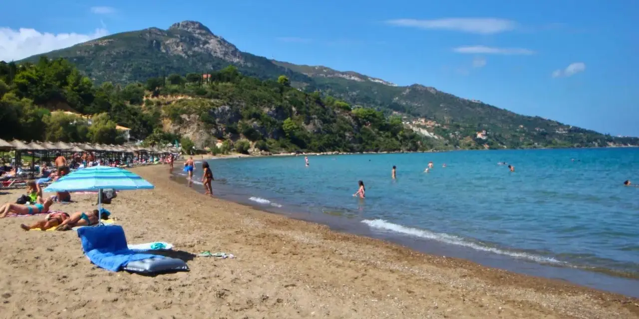 Idealna zakynthos pogoda sierpień: słońce, plaża, morze i ludzie kąpiący się w wodzie.