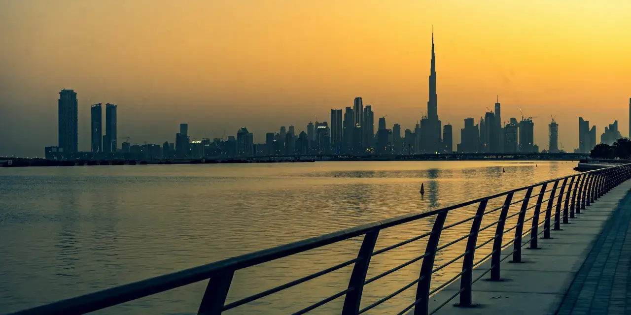 Zachód słońca nad Dubajem. Zjednoczone Emiraty Arabskie ciekawostki: najwyższy budynek świata, Burj Khalifa, góruje nad panoramą miasta.
