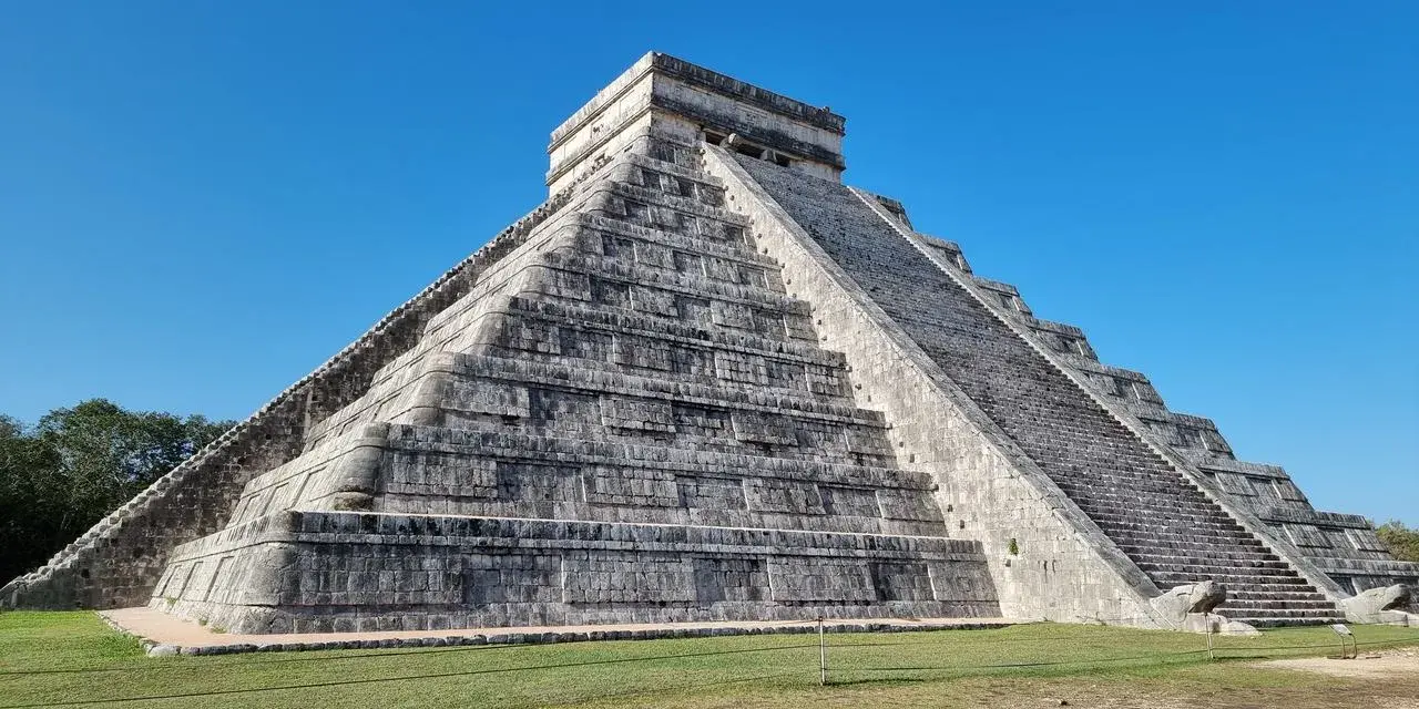 Piramide Kukulkana w Chichen Itza, jeden z Nowych Siedmiu Cudów Świata, majestatycznie wznosi się na tle błękitnego nieba.