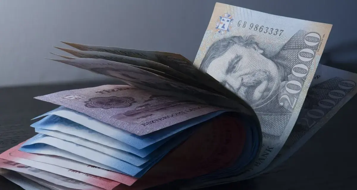 Stos banknotów, w tym 20 000 forintów, sugeruje, że budapeszt jaka waluta to forint węgierski.