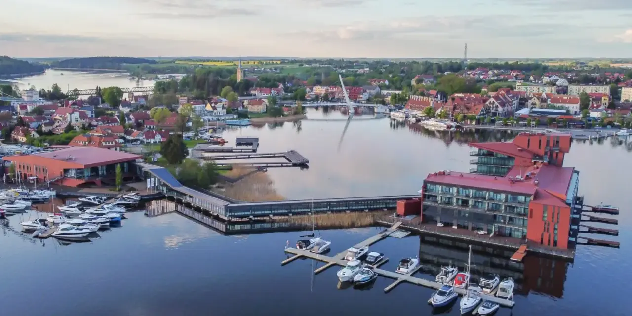 Widok z lotu ptaka na nowoczesny hotel i przystań jachtową na Mazurach.