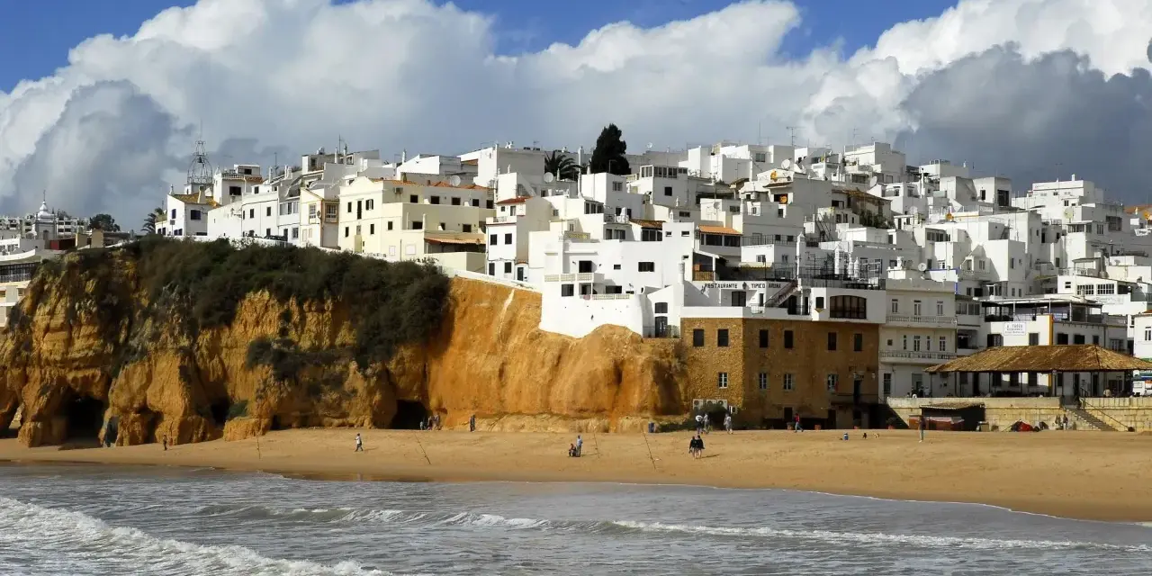 Białe domy na klifie, plaża i morze. Portugalia pogoda roczna, idealna na spacer.
