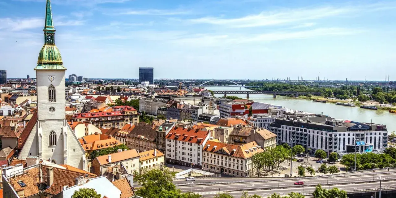 Widok na Bratysławę: wieża katedry, rzeka Dunaj i dachy Starego Miasta.