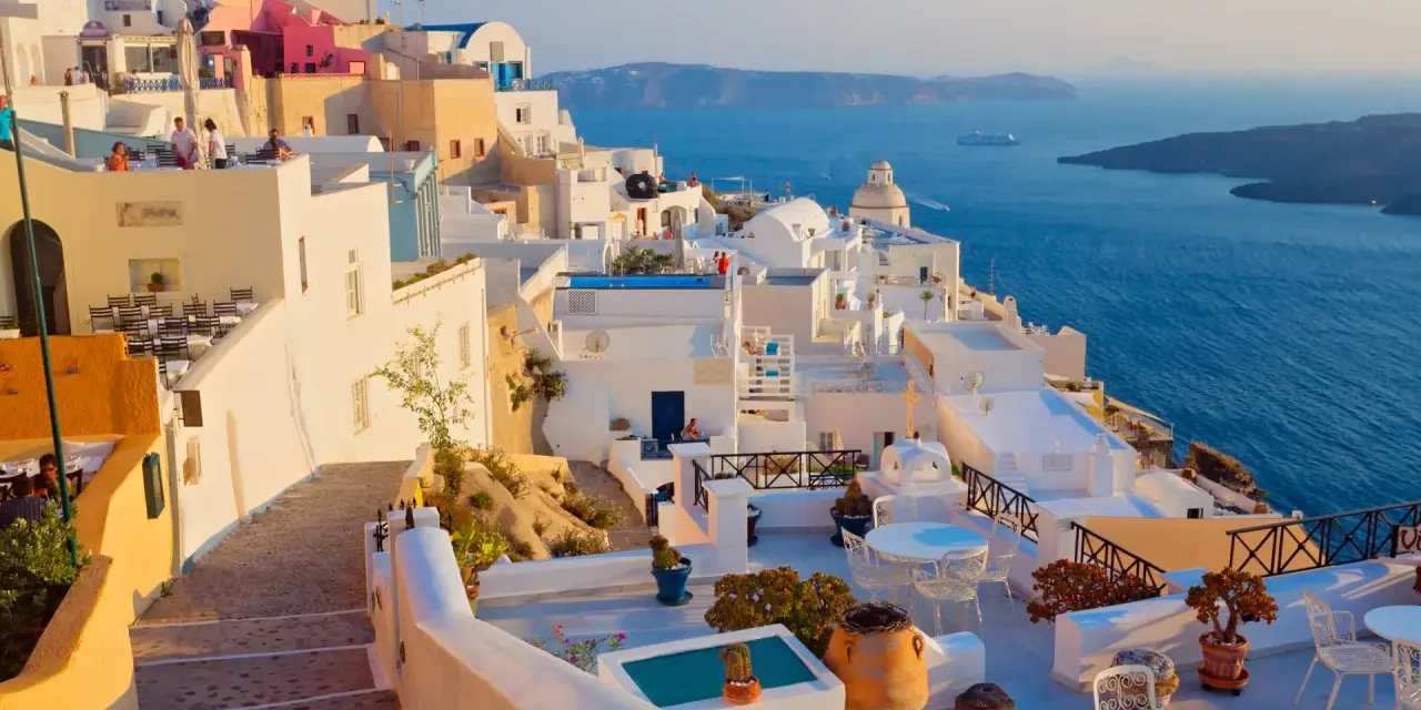 Białe domy na klifie z widokiem na błękitne morze, Santorini.