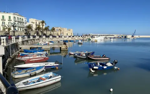 Widok na port w Bari z łodziami i budynkami w tle.