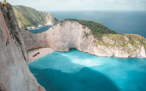 Zatoka Wraku na Zakynthos z turkusową wodą i klifami.