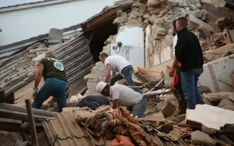 Ratownicy przeszukują gruzy po trzęsieniu ziemi we Włoszech. Zniszczone budynki i chaos po katastrofie.