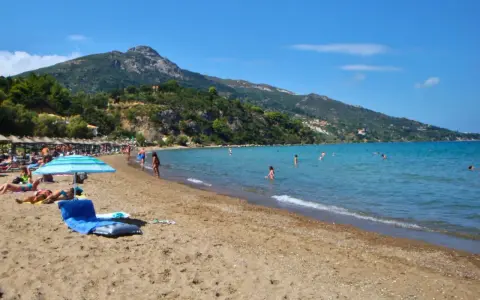 Idealna zakynthos pogoda sierpień: słońce, plaża, morze i ludzie kąpiący się w wodzie.