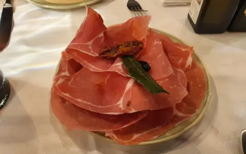 Plastry prosciutto na talerzu, idealne na przystawkę we Florencji. Co zjeść? Prosciutto to świetny wybór!