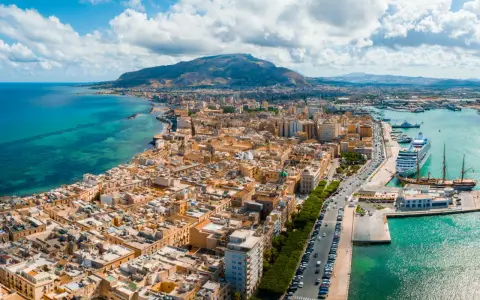 Widok na Trapani, Sycylia. Miasto z widokiem na turkusowe morze i góry. Zobacz, co warto zobaczyć w Trapani: port z luksusowym rejsem i zabytkowymi żaglowcami.