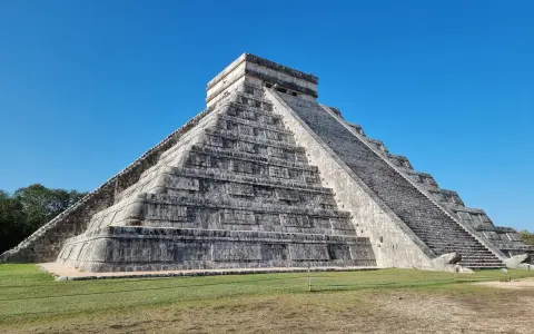 Piramide Kukulkana w Chichen Itza, jeden z Nowych Siedmiu Cudów Świata, majestatycznie wznosi się na tle błękitnego nieba.