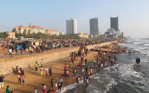 Tłum ludzi na plaży w Sri Lance w listopadzie. Pogoda słoneczna, idealna na spacer i kąpiel w oceanie.