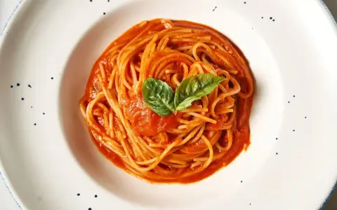 Pyszne spaghetti z sosem pomidorowym i bazylią. Prawdziwa **Italia na talerzu**, która rozpływa się w ustach.