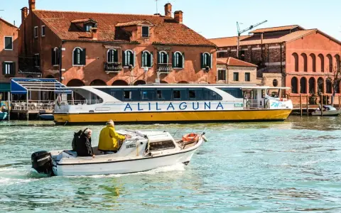 Jak dojechać z lotniska Treviso do Wenecji? Prom Alilaguna to świetna opcja. Widok na kanał i tradycyjną architekturę.